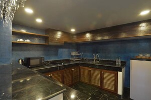 Una cocina moderna con encimeras oscuras, armarios de madera y un microondas integrado.
