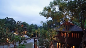 A secluded resort with multiple wooden cabins surrounded by lush greenery and a calm lake. - Chantra Khiri Chalet Chiang Mai (Hang Dong)