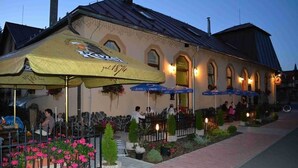 Un edificio con terraza al aire libre y sombrillas, que muestra la fecha '1874' en la fachada.