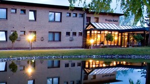 Un hotel reflejado en aguas tranquilas, rodeado de una costa rocosa.