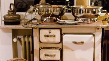 Un poêle ancien doté de plusieurs brûleurs et d’une étagère pour les casseroles au-dessus.