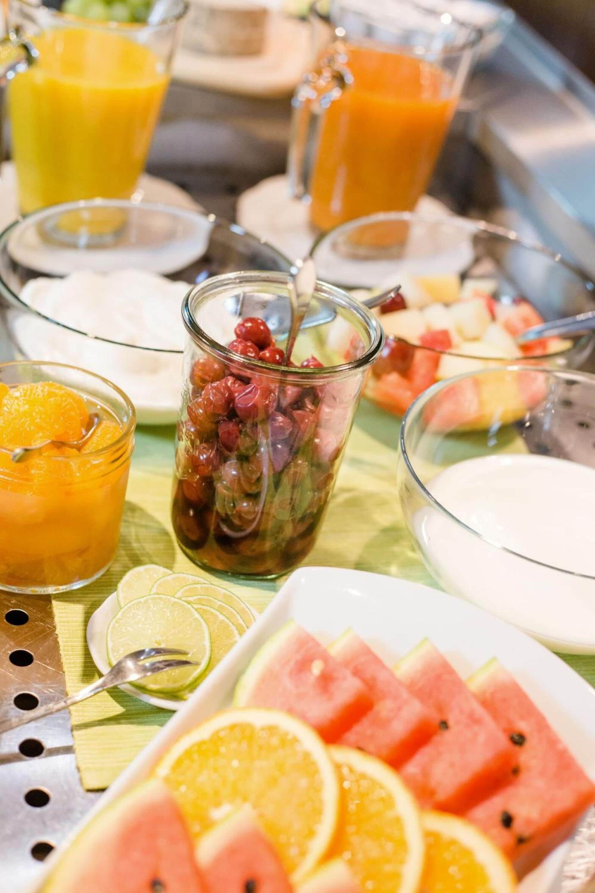 A breakfast buffet with various fruits and beverages.