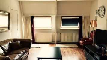 Klassieke penthouse, 1 kingsize bed, uitzicht op stad | Woonkamer | Een flatscreentelevisie