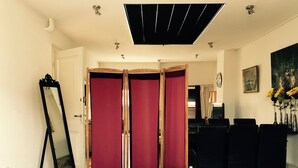 Une chambre à coucher avec un grand lit, un miroir, un bureau avec des chaises et un tableau accroché au mur.