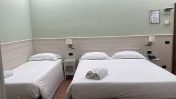 Une chambre double avec deux lits simples, une table de chevet avec un téléphone, une prise électrique et une lampe.