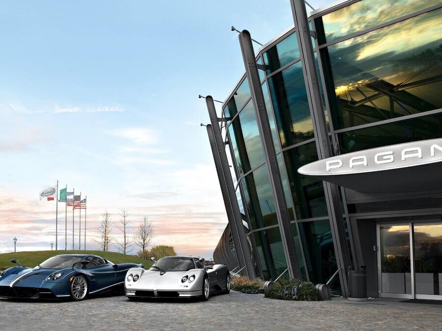 Un edificio moderno con una grande facciata vetrata e un'insegna ben visibile con la scritta "PAGANI".