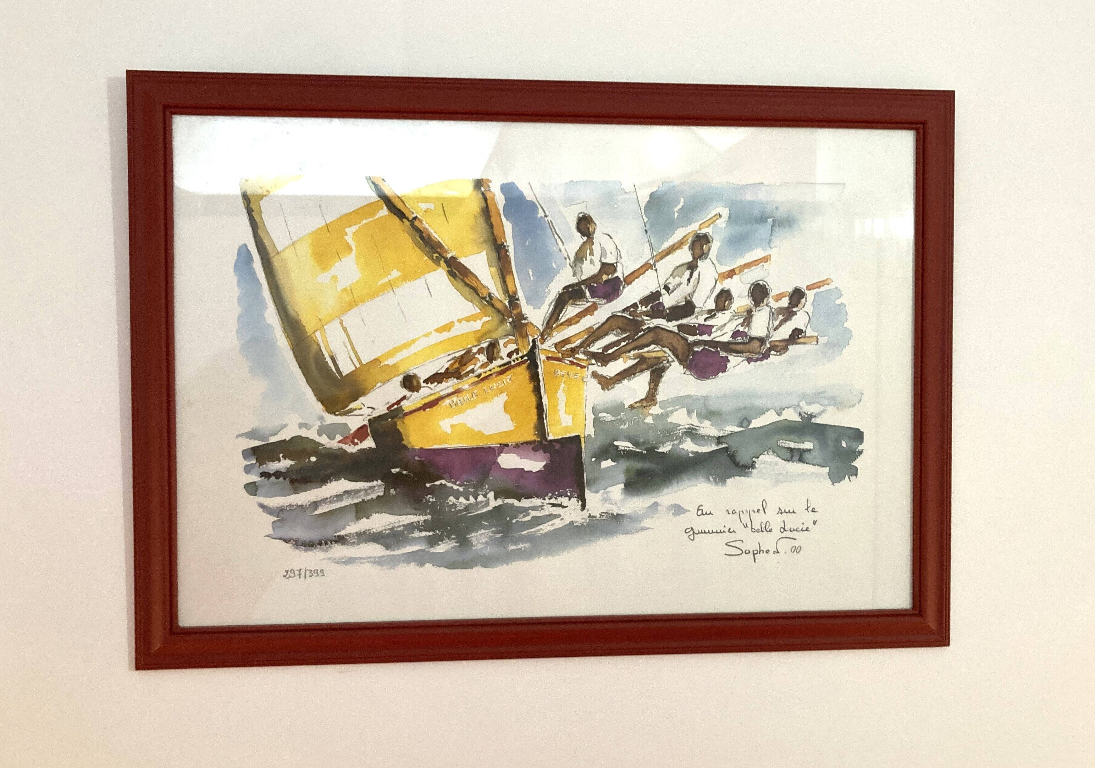 A framed artwork of a sailboat with people on board, signed by the artist.