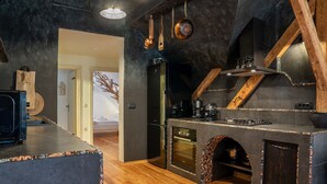 Eine moderne Küche mit Einbauofen, einem schwarzen Kühlschrank und Holzelementen.