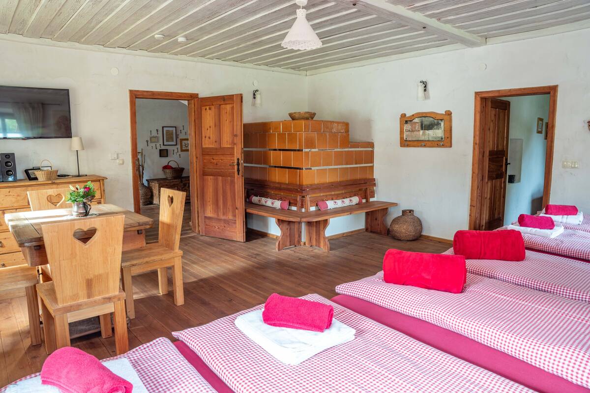 Ein Zimmer mit Holzmöbeln, karierten Betten und einem Fernseher.