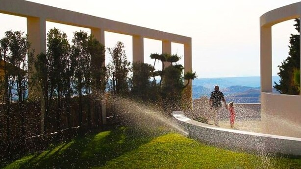 A modern building with a curved pathway, surrounded by greenery and trees. - Agriturismo Campo Allegro (Santa Ninfa)