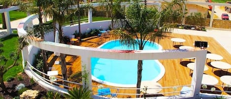 Una piscina al aire libre de temporada, sombrillas