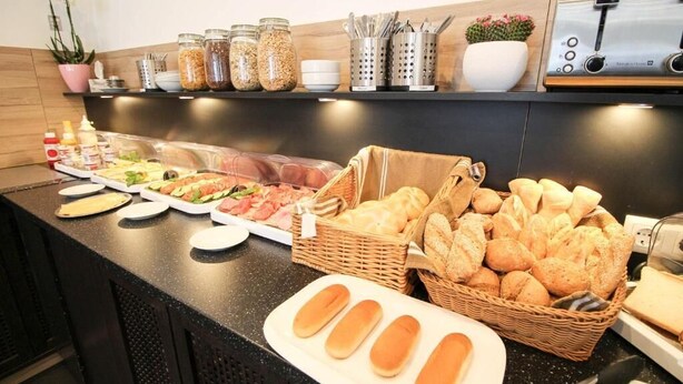 A buffet with various food items, including bread, salads, and meats. - Center Hotel Essen (Essen)