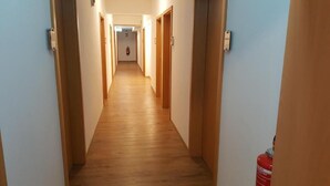 A narrow hallway with wooden flooring and doors on both sides. - Center Hotel Essen (Essen)