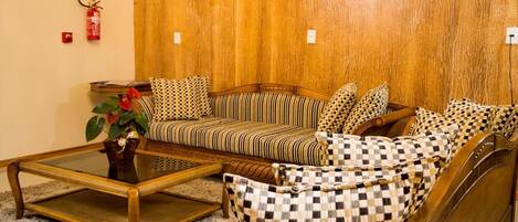 A cozy living room with a sofa set, a coffee table, and a patterned armchair.