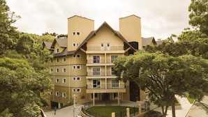 A multi-story hotel with a symmetrical facade, balconies, and a central entrance. - Sky Serra Hotel (Gramado)