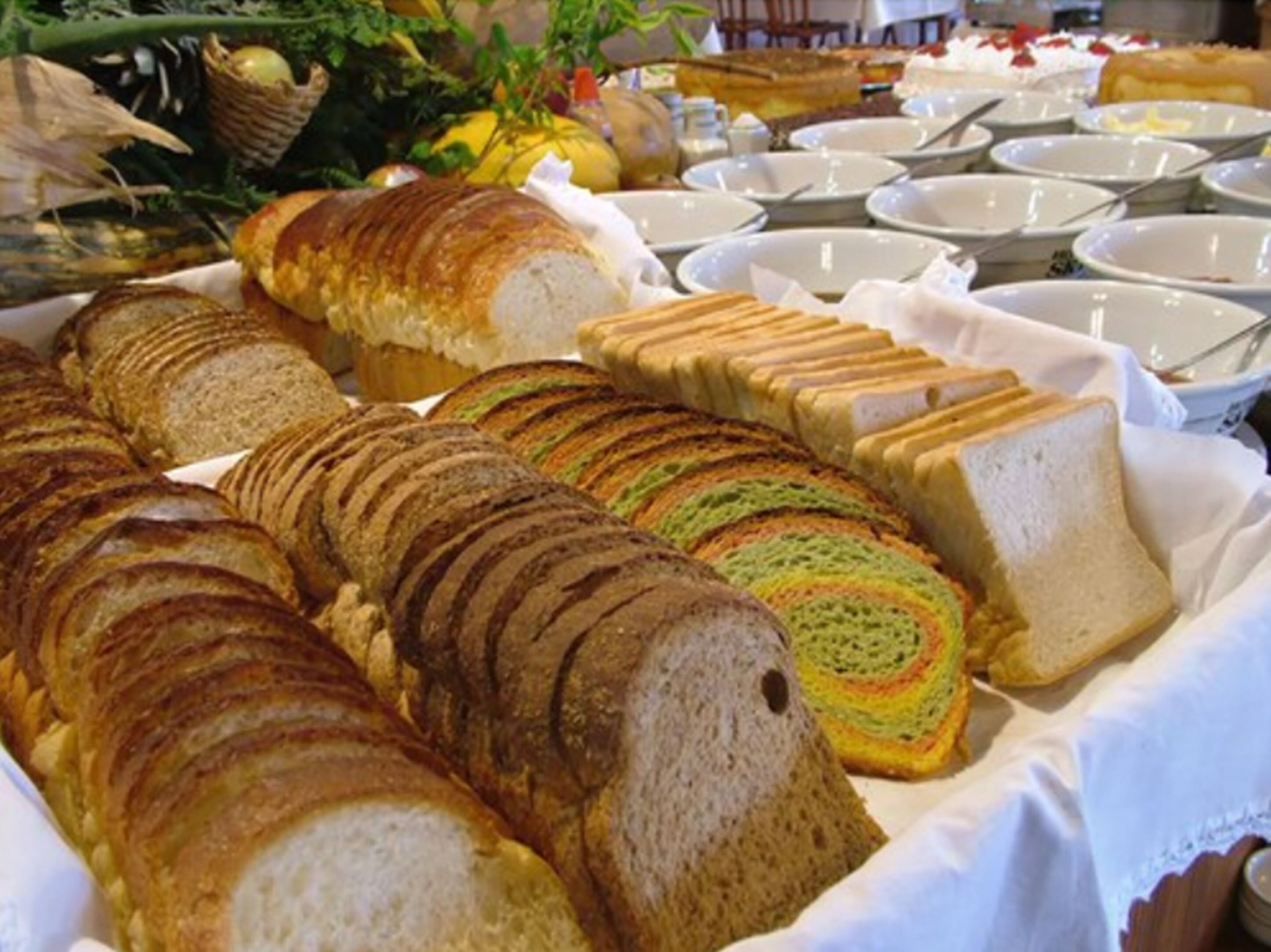 A buffet with various breads and pastries.
