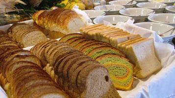 Un bufé con panes y pasteles varios.