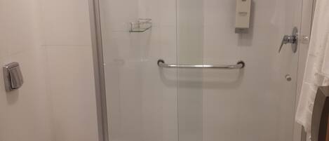 Un baño moderno con cabina de ducha de vidrio, inodoro y encimera de granito.