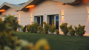 A modern building with a flat roof, multiple windows, and outdoor lighting. - La Vida Otel (Urla)