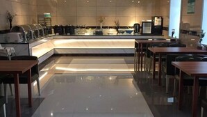 Un hall d’hôtel moderne avec un comptoir d’accueil en marbre, un espace salon et une machine à café.
