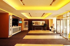 A hotel lobby with a reception desk, seating area, and a large window. - Jinjiang Inn (Siping Pingdong Road Wanda Plaza) (Siping)