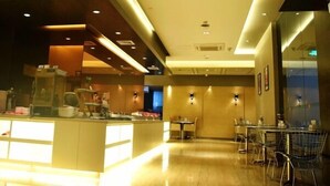 Un vestíbulo de hotel moderno con recepción, zona de estar y una partición de vidrio.
