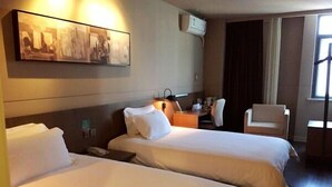 A hotel room with two beds, a desk, a chair, and a wall-mounted air conditioner. - Jinjiang Inn Select Shanghai Chuansha Subway Station (Shanghai)