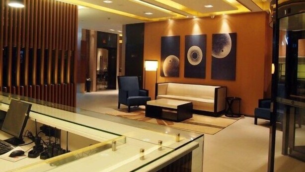 A modern lobby with a reception desk, seating area, and artwork on the wall. - Jinjiang Inn Select Shanghai Chuansha Subway Station (Shanghai)