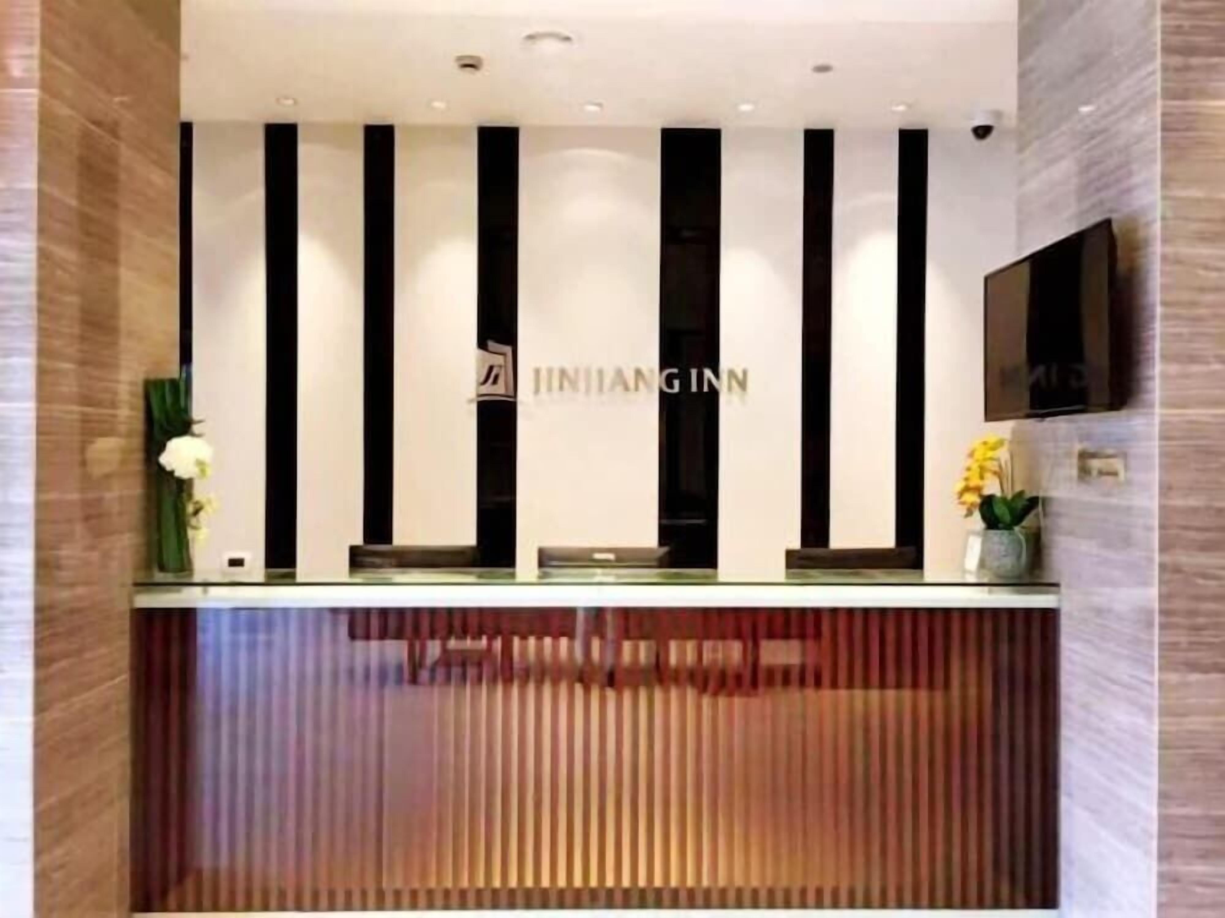 Un mostrador de recepción de diseño moderno, con rayas verticales blancas y negras y un logotipo.