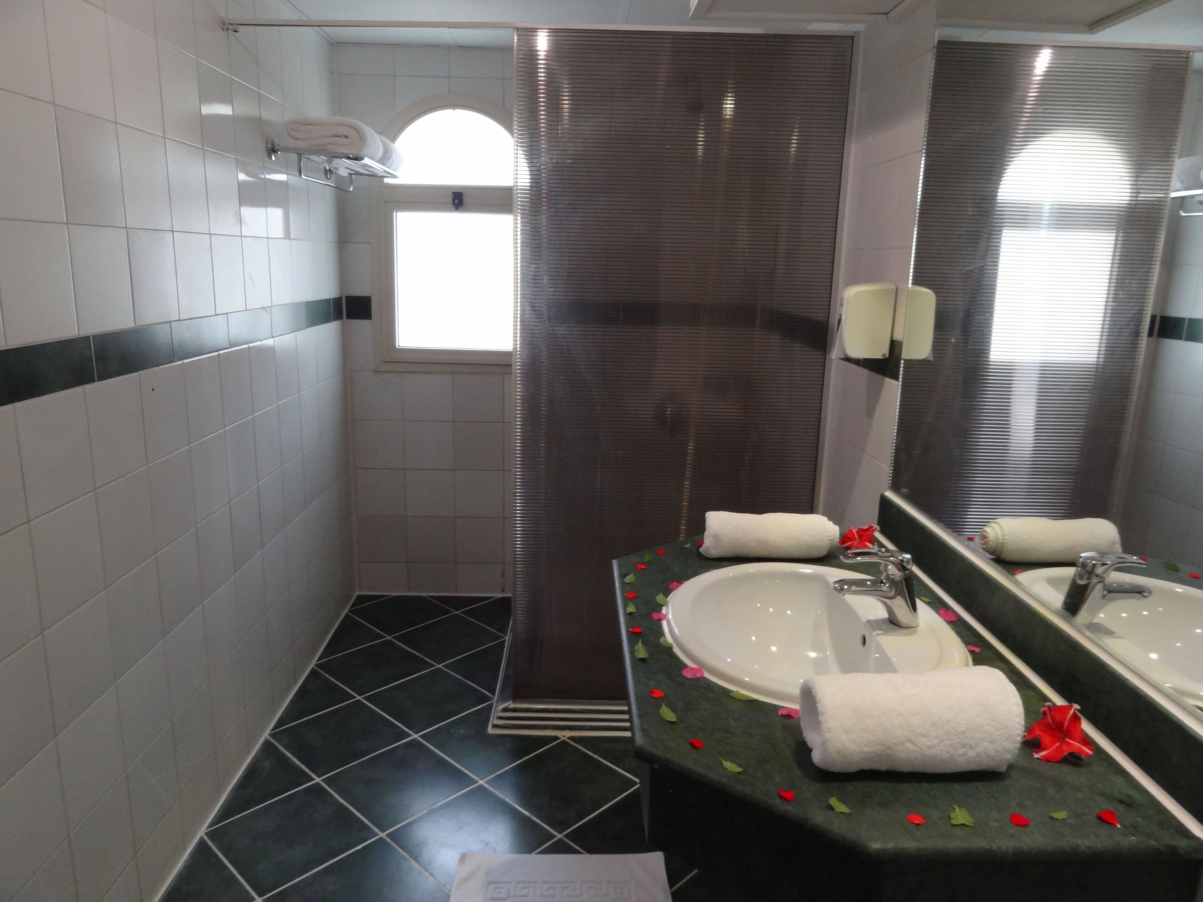 A bathroom with a sink, mirror, and shower curtain.