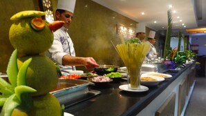 A buffet setup with various food items and a chef preparing food. - Naama Blue hotel (Sharm El Sheikh)