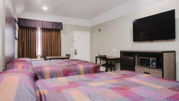 A hotel room with two beds, a desk, a chair, a television, and a microwave.