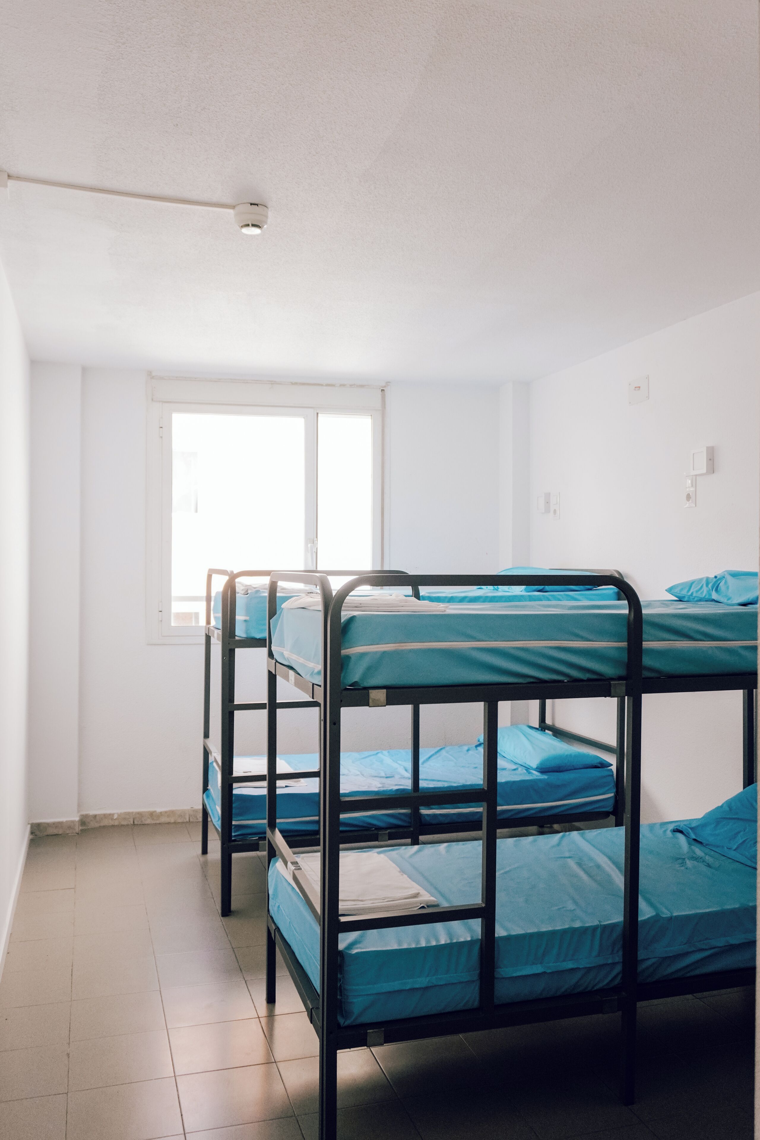 Un dormitorio con literas, una ventana y una lámpara en el techo.