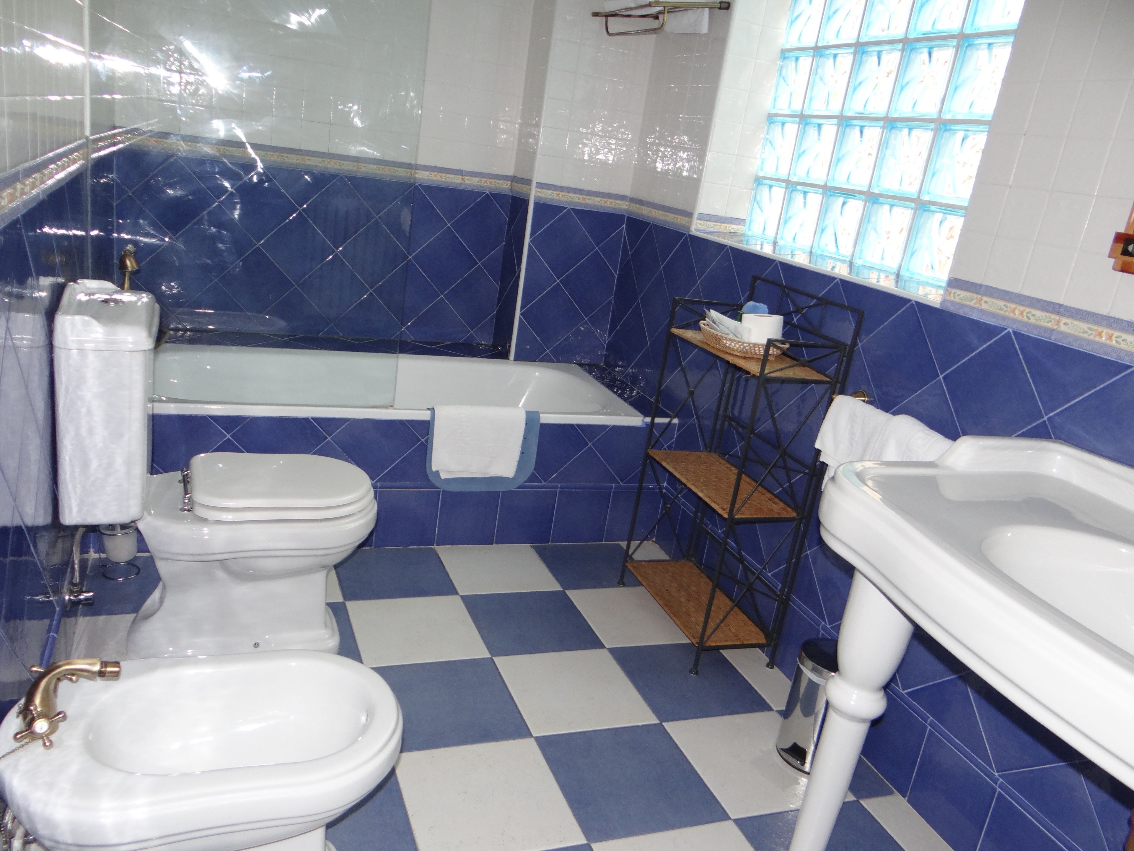 Un bany amb un terra de pissos, una banyera, un vàter i un lavabo.