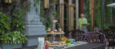 A table set with a variety of desserts and snacks, a sign indicating Häagen-Dazs, and a person in the background.