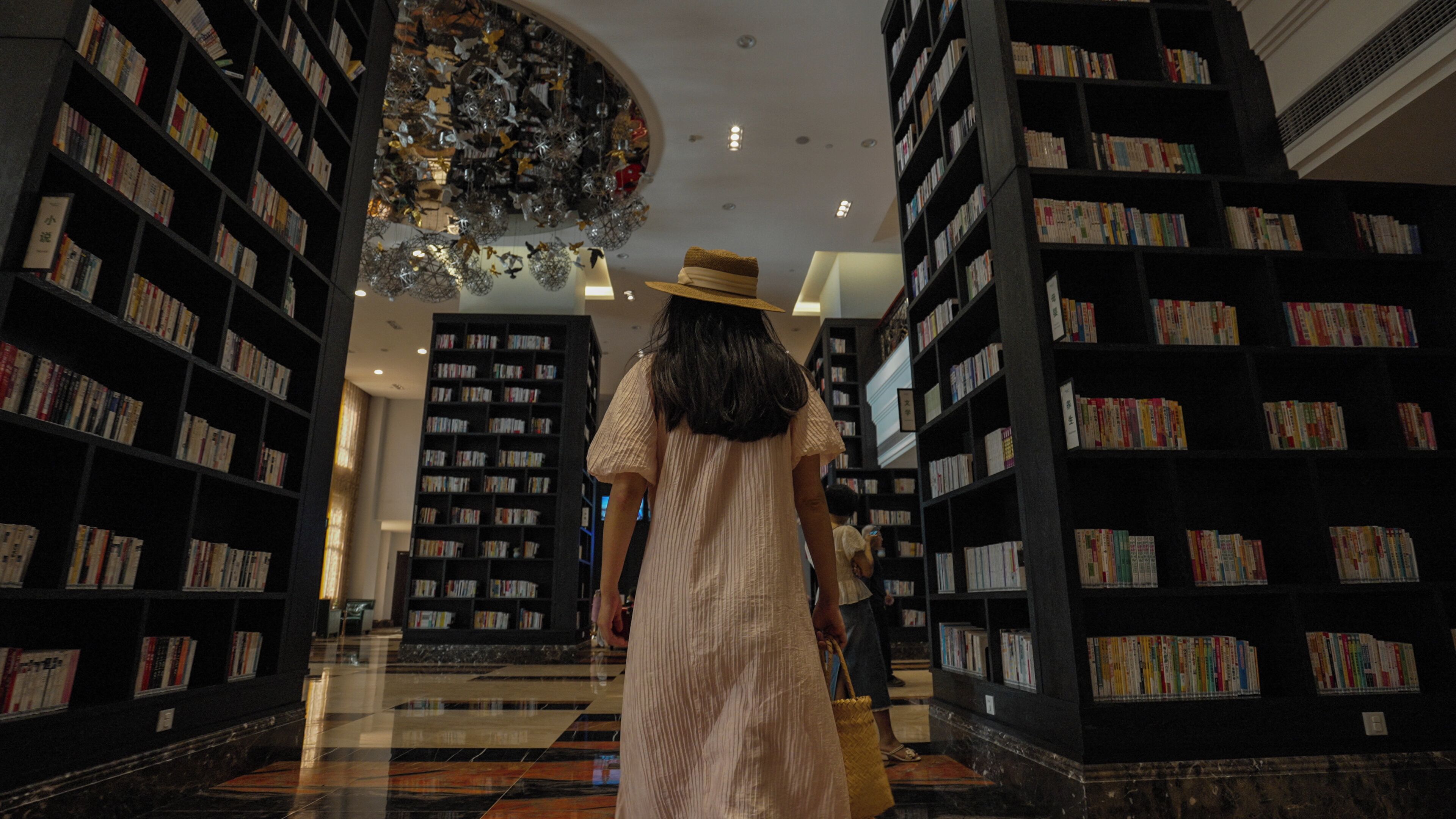 Interior de una biblioteca con estanterías a ambos lados y un pasillo central.