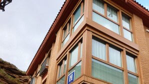 Een hotel met meerdere verdiepingen, een gevel van baksteen, grote ramen en een zichtbare garagepoort.