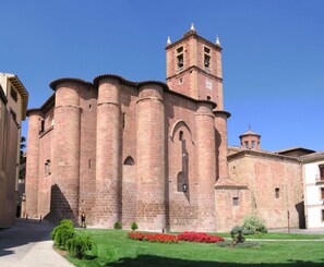 A historic building with a prominent bell tower and arched windows. - Hostal Ciudad de Nájera (Najera)