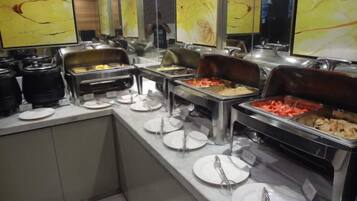 Ein Buffet mit verschiedenen Speisebereichen, darunter ein Bereich für warme Speisen und ein Bereich für kalte Speisen.