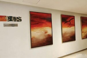 Una pared con tres cuadros enmarcados y un letrero con caracteres chinos.