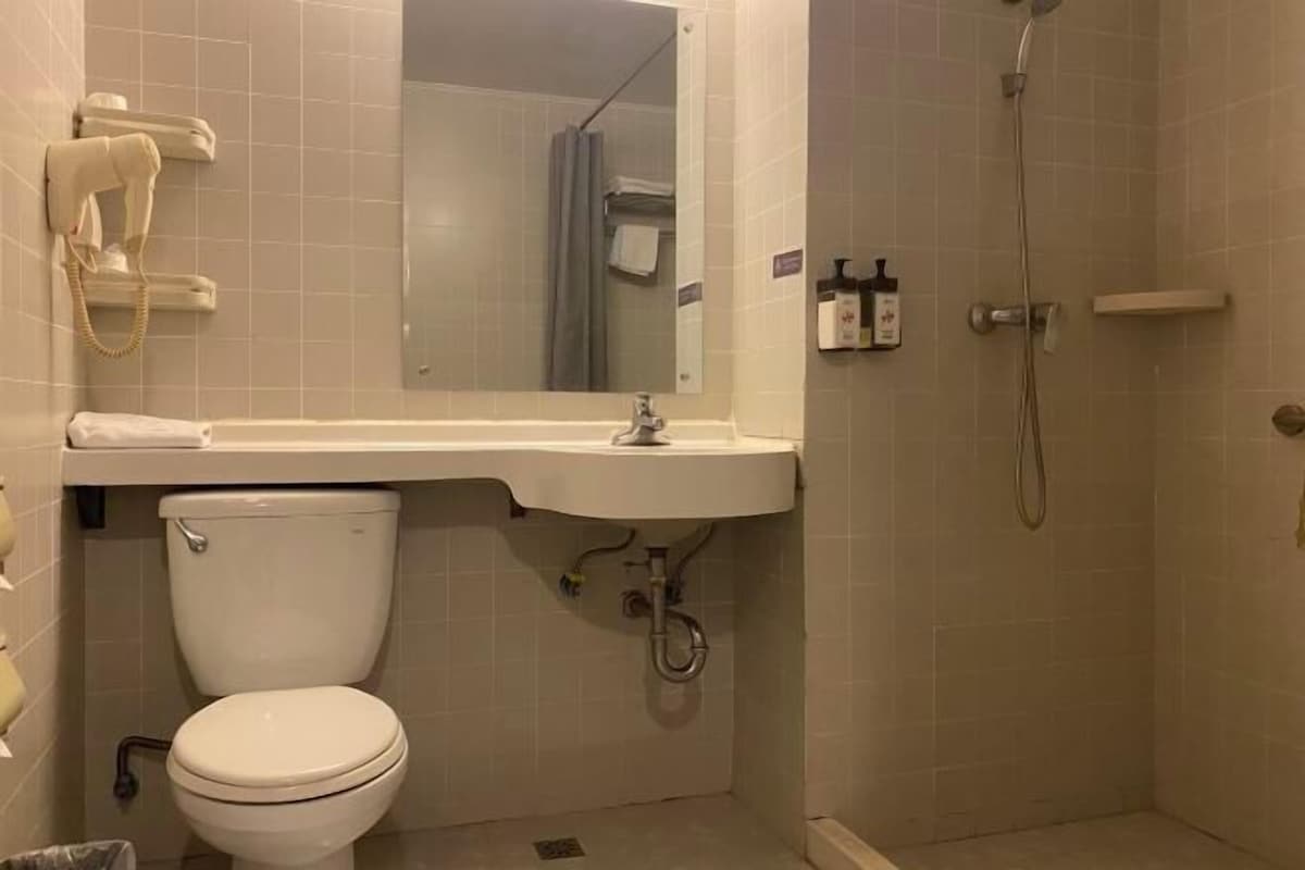 A bathroom with a toilet, sink, and shower.