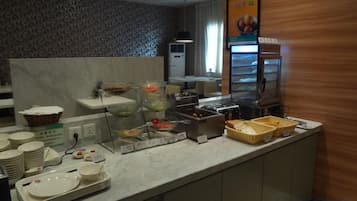A buffet setup with various food containers and serving dishes.