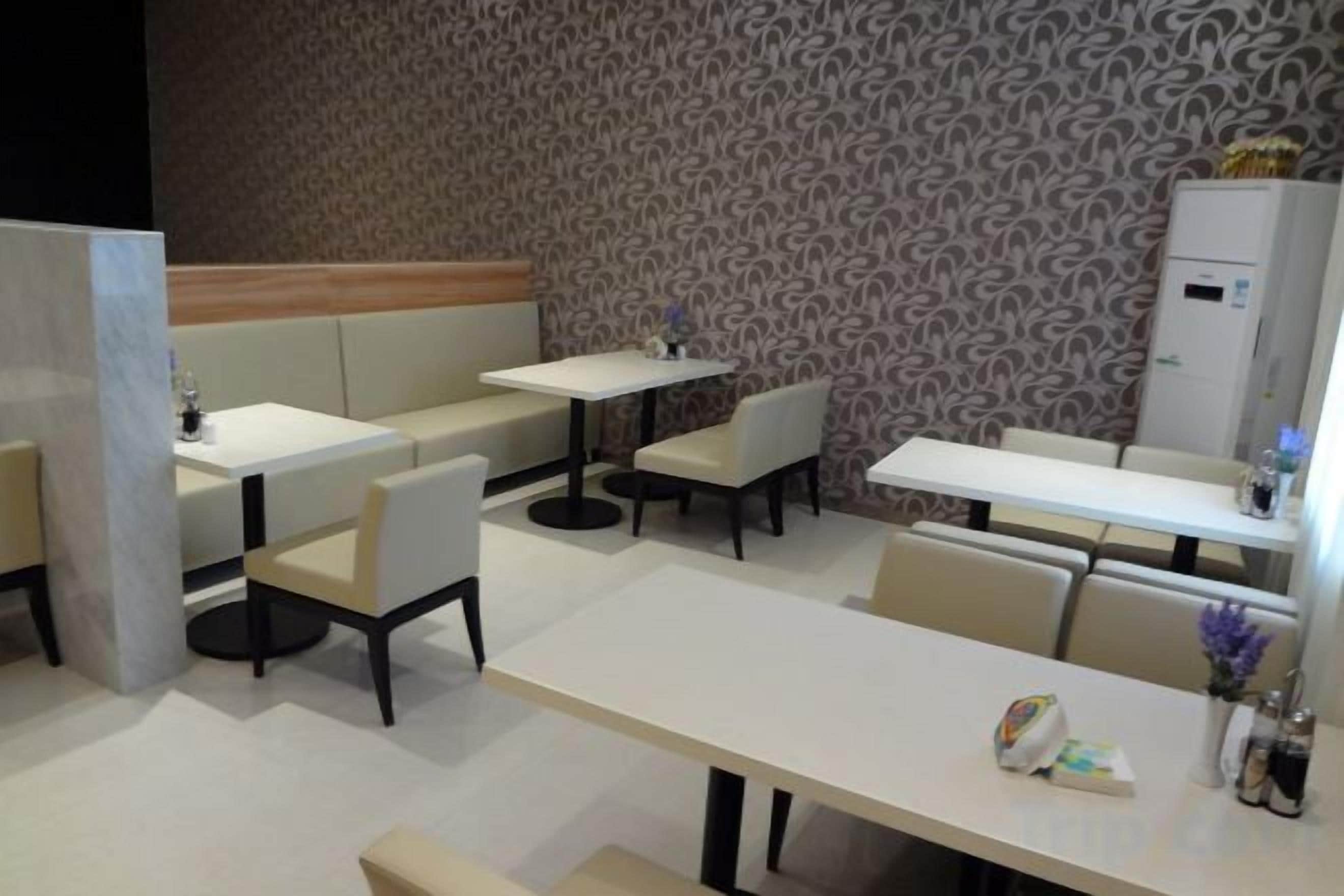 Un restaurante con cabinas, mesas y una pared con diseño.