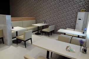Un restaurante con cabinas, mesas y una pared con diseño.