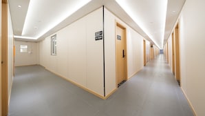 A long, well-lit hallway with doors numbered 215 and 216, leading to rooms. - Dunbar Inn Zhenbein Road (Shanghai)