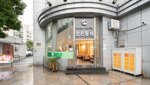 The exterior of a modern building with a sign for DENGBA HOSTEL. - Dunbar Inn Zhenbein Road (Shanghai)