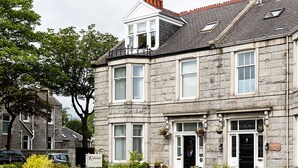 A stone building with a traditional facade, multiple windows, and a front door with a sign above it. - Kildonan Guesthouse (Aberdeen)