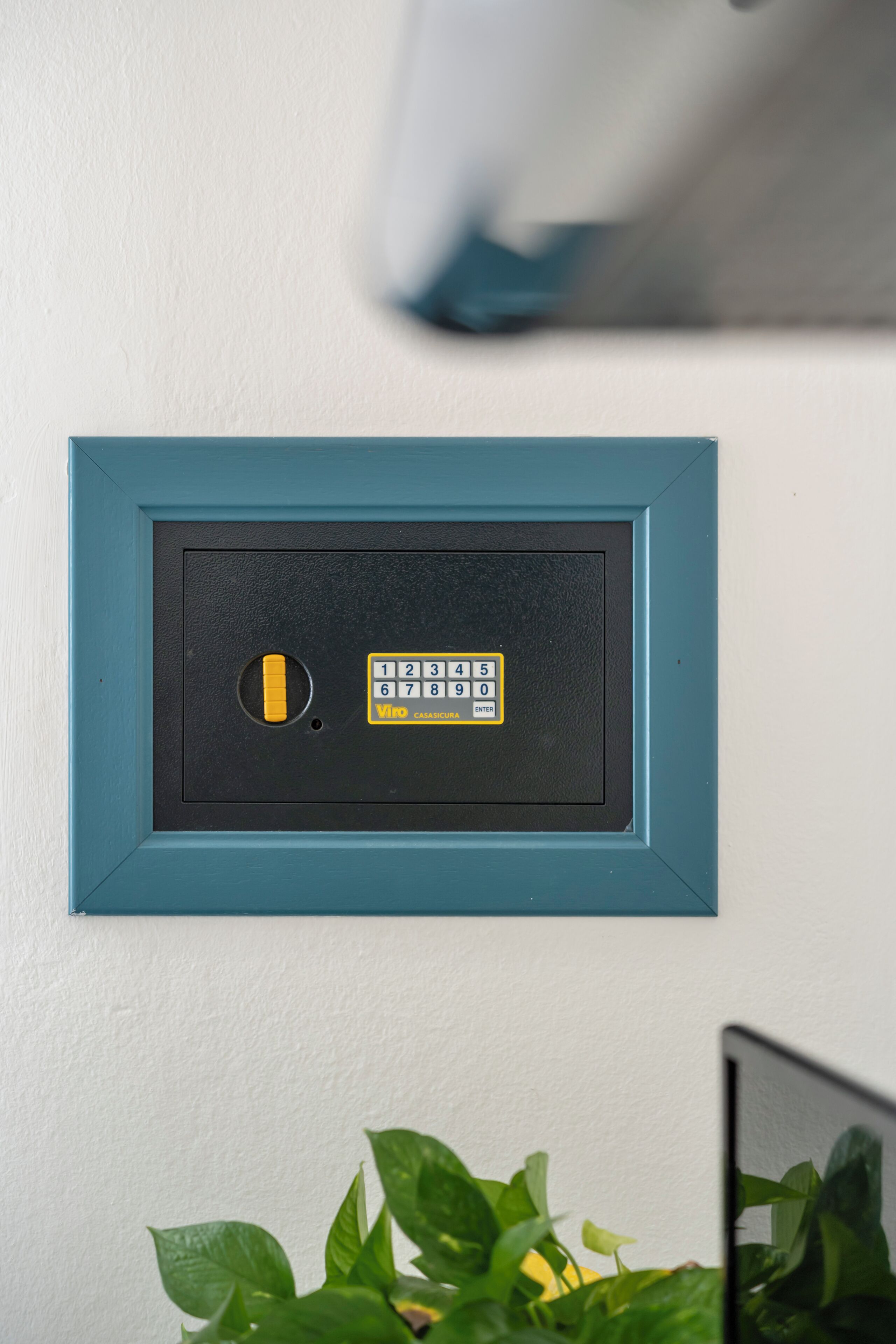 Un clavier de sécurité à cadre bleu, fixé sur un mur blanc.