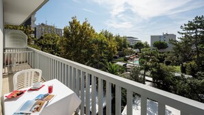 A balcony with a white table, chairs, and a magazine.