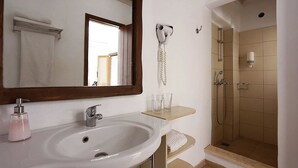 A bathroom with a sink, mirror, towel rack, and shower. - Albatros Club Mykonos (Mykonos)